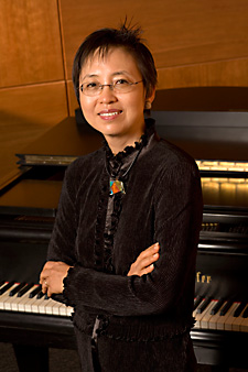 Photo of Hi Kyung Kim in front of piano